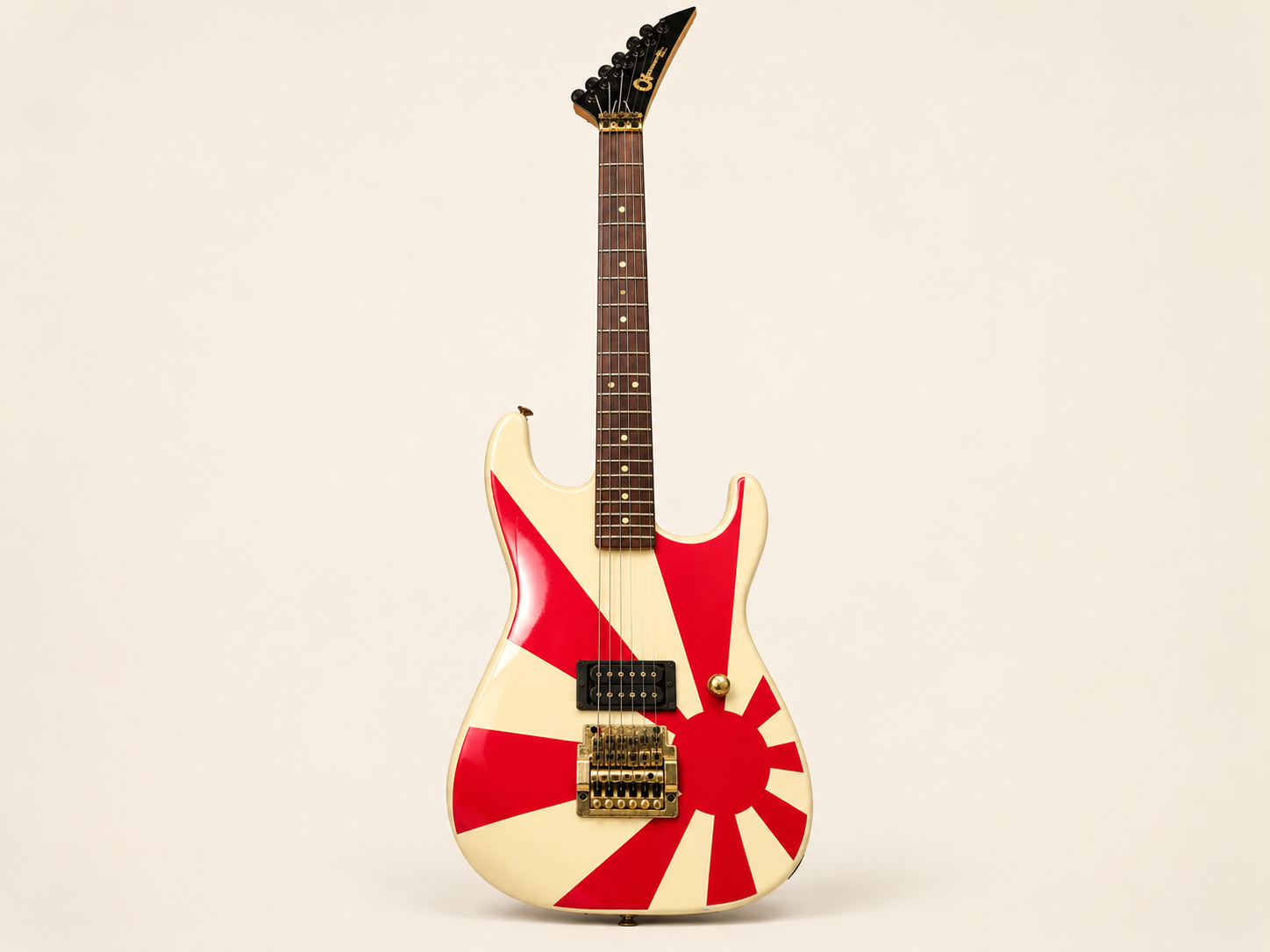 Doug Perlson’s red-and-cream 1980s Charvel guitar, photographed against a warm neutral studio background